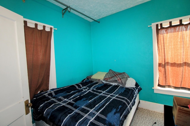 bedroom featuring a textured ceiling and baseboards