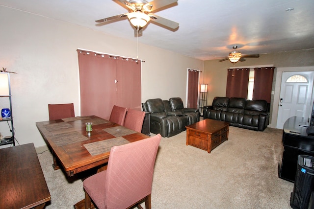 dining space with a ceiling fan and carpet flooring