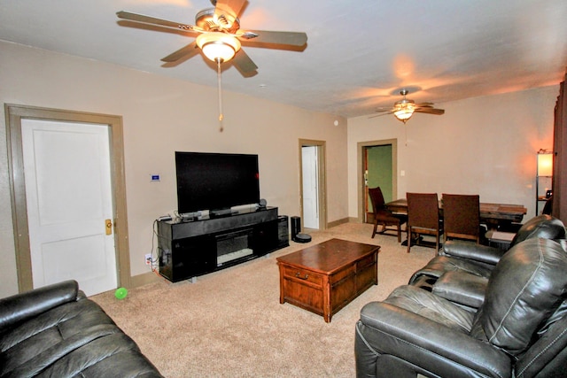 carpeted living room with a ceiling fan and baseboards