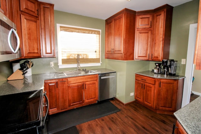 kitchen featuring appliances with stainless steel finishes, a sink, baseboards, and dark wood-style floors