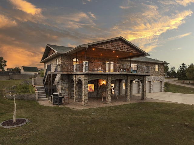 view of front facade featuring a garage, a front yard, stairs, driveway, and a patio area