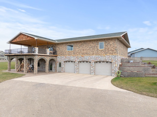 view of front of house featuring brick siding, concrete driveway, a balcony, an attached garage, and a front yard