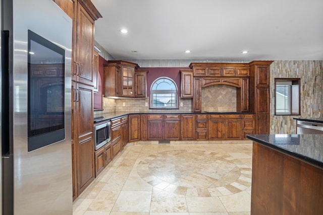 kitchen featuring dishwasher, backsplash, glass insert cabinets, and recessed lighting