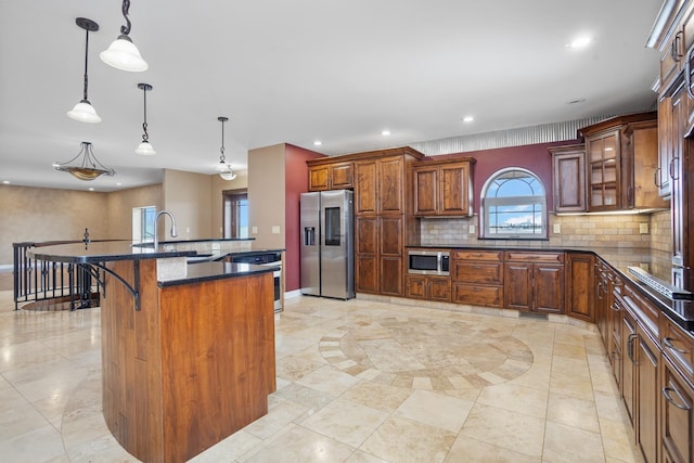 kitchen with tasteful backsplash, recessed lighting, appliances with stainless steel finishes, a sink, and a kitchen bar