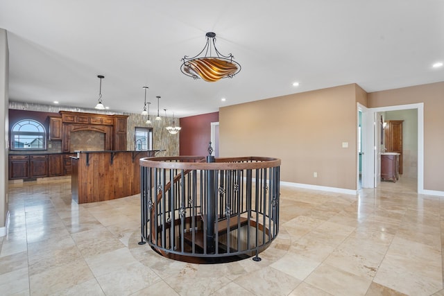 kitchen with baseboards, dark countertops, a breakfast bar, hanging light fixtures, and recessed lighting