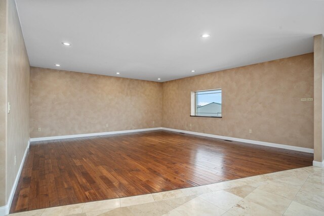 spare room with baseboards, hardwood / wood-style floors, and recessed lighting