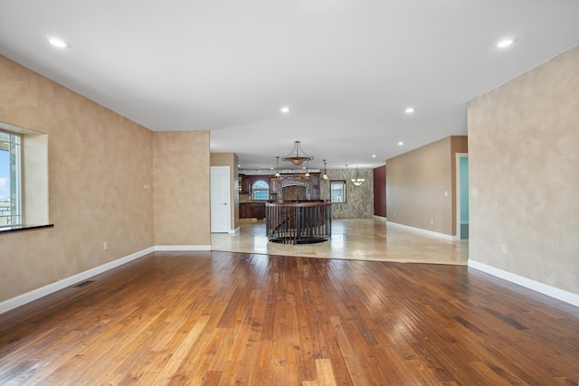 unfurnished living room with recessed lighting, visible vents, light wood-style flooring, and baseboards