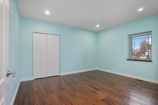 unfurnished bedroom featuring recessed lighting, visible vents, baseboards, a closet, and wood-type flooring