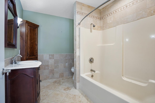 full bathroom featuring tile walls, toilet, tub / shower combination, vanity, and tile patterned floors