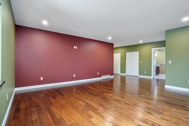 spare room with recessed lighting, visible vents, baseboards, and hardwood / wood-style flooring