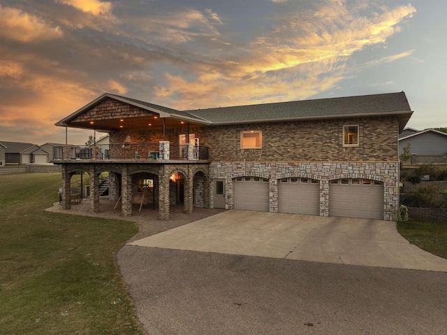 view of front of home featuring a garage, a patio area, driveway, and a front lawn