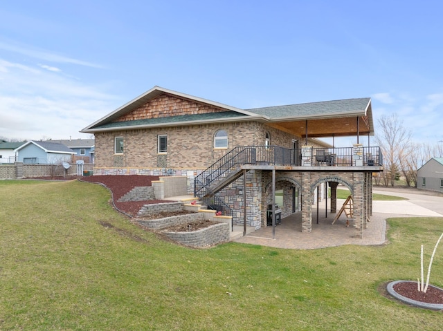 back of property with stairway, a lawn, a patio area, and brick siding