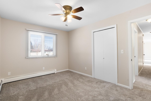 unfurnished bedroom featuring a baseboard radiator, carpet flooring, a ceiling fan, baseboards, and a closet