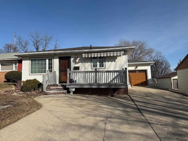 view of front of house with a garage, an outbuilding, and driveway