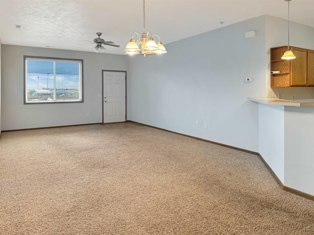 spare room with light colored carpet, a textured ceiling, ceiling fan with notable chandelier, and baseboards