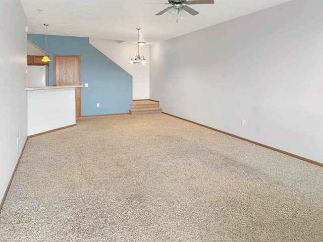 interior space with light colored carpet, ceiling fan with notable chandelier, and baseboards