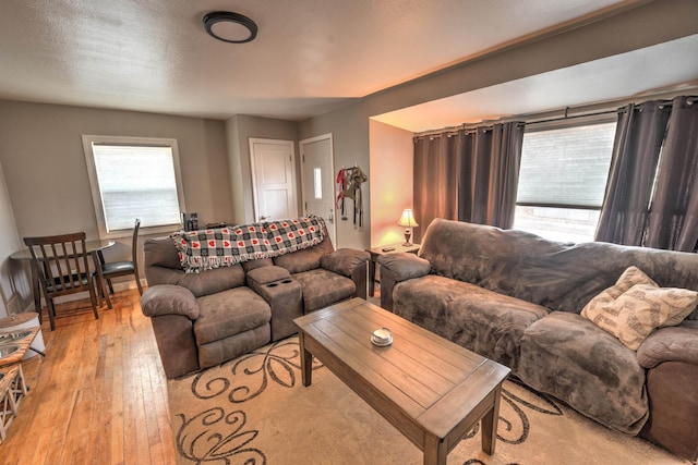 living room with light wood-style floors and a textured ceiling