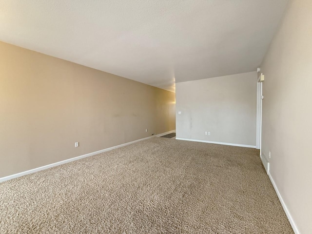 carpeted empty room featuring baseboards