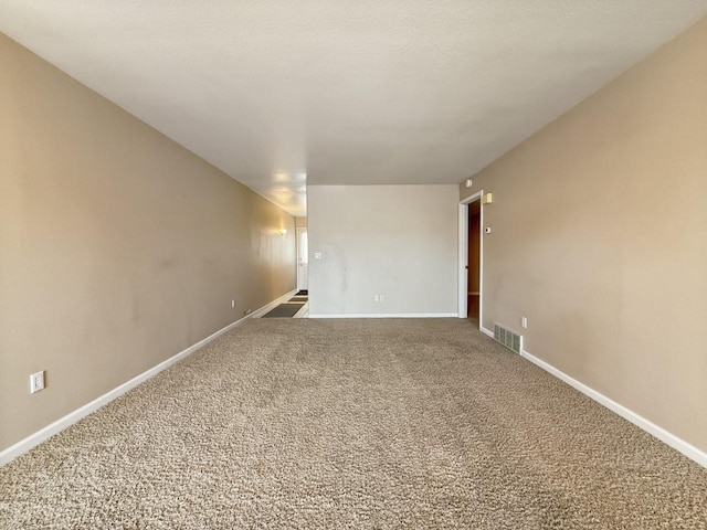 unfurnished room with baseboards, visible vents, and carpet floors