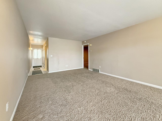 carpeted empty room with visible vents and baseboards