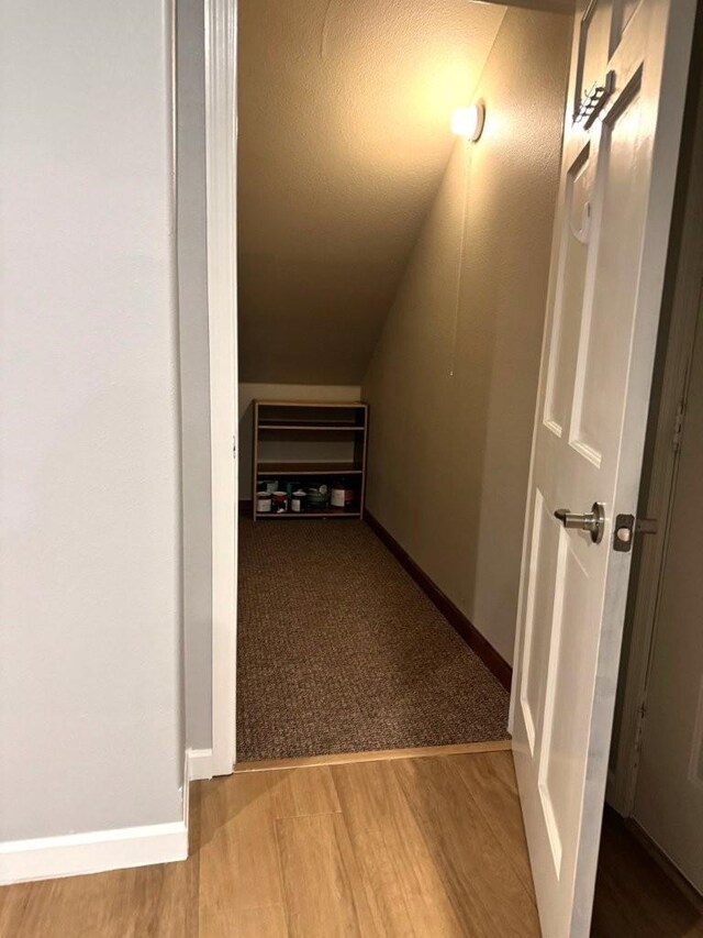 hallway with baseboards and wood finished floors