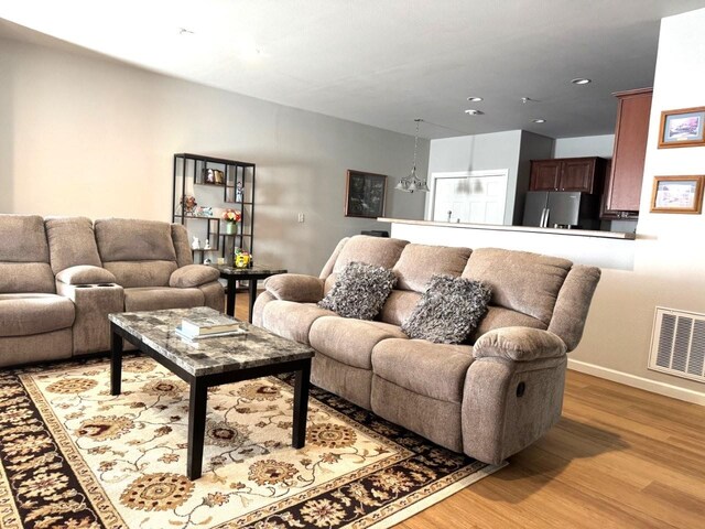 living area with recessed lighting, baseboards, visible vents, and light wood-type flooring