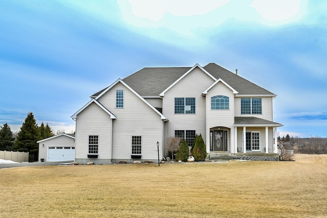 traditional home featuring fence, roof with shingles, a front lawn, an outdoor structure, and a garage