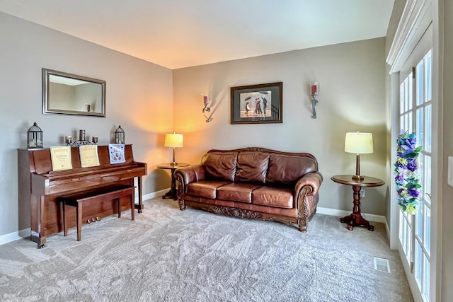 living area featuring visible vents, carpet, and baseboards