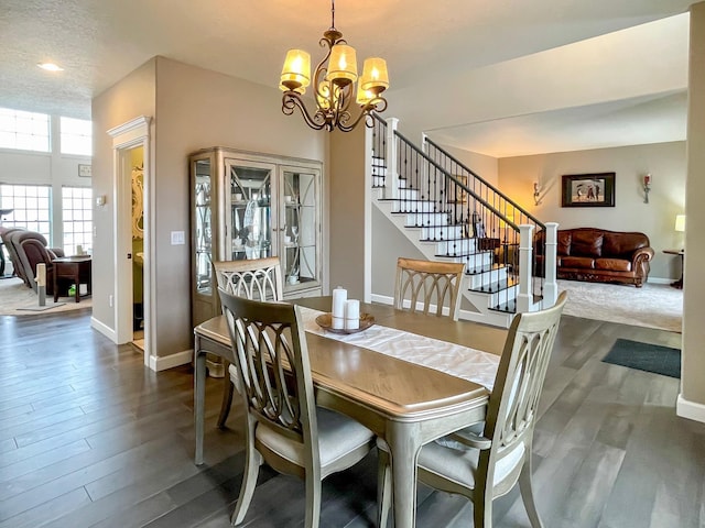 dining room featuring stairway, baseboards, a notable chandelier, and dark wood-style floors