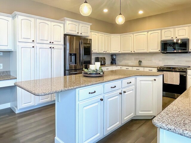 kitchen with light stone countertops, decorative backsplash, white cabinets, stainless steel appliances, and dark wood-style flooring