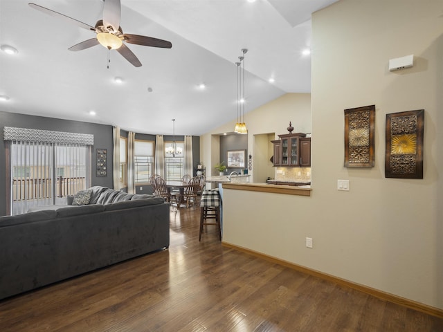 living area with vaulted ceiling, a ceiling fan, dark wood-style flooring, and baseboards