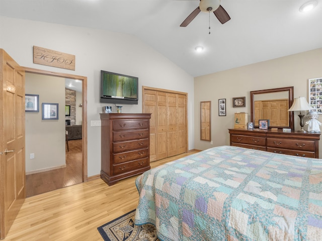 bedroom featuring baseboards, ceiling fan, light wood-type flooring, vaulted ceiling, and a closet