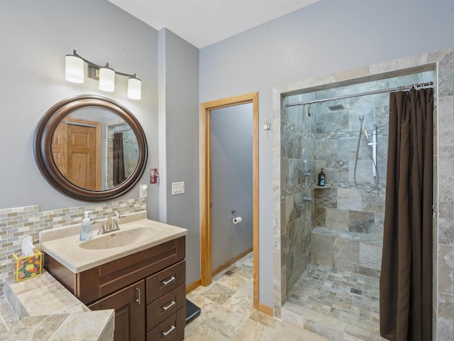 bathroom featuring tasteful backsplash, a stall shower, vanity, and baseboards