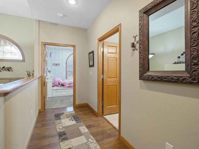 hallway featuring baseboards and wood finished floors