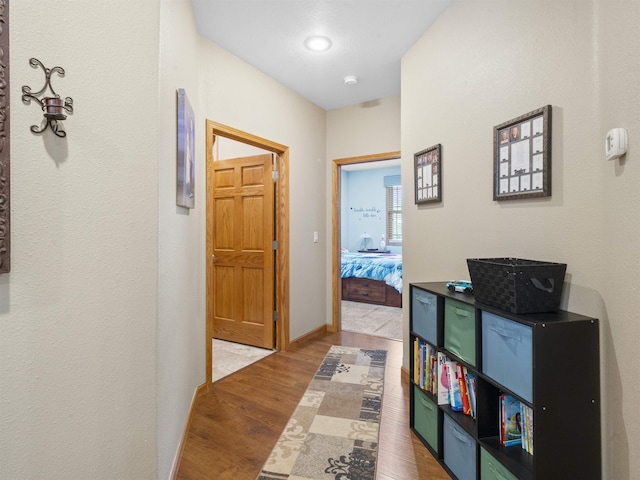 hallway featuring baseboards and wood finished floors