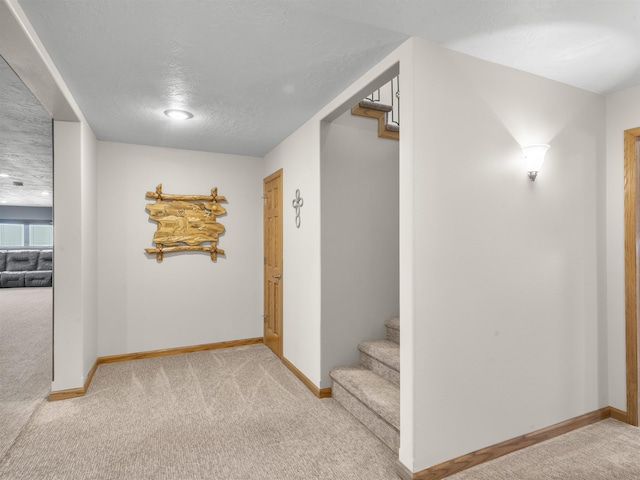 hall with stairway, carpet, and baseboards