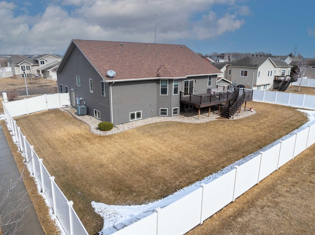 rear view of house featuring a residential view, a wooden deck, a lawn, a fenced backyard, and a gate