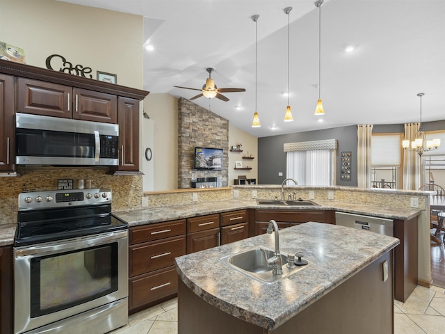 kitchen with ceiling fan with notable chandelier, appliances with stainless steel finishes, a peninsula, and a sink