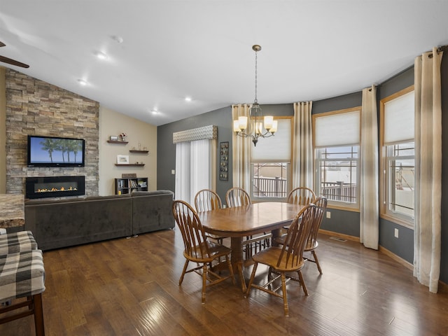 dining room with a fireplace, baseboards, lofted ceiling, and dark wood-style flooring