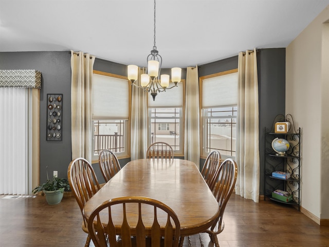 dining area featuring a notable chandelier, baseboards, and wood finished floors