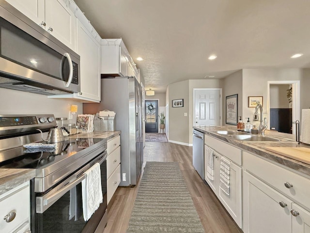 kitchen featuring a sink, light countertops, white cabinets, stainless steel appliances, and dark wood-style flooring