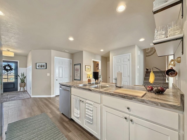 kitchen featuring dishwasher, recessed lighting, wood finished floors, white cabinetry, and a sink