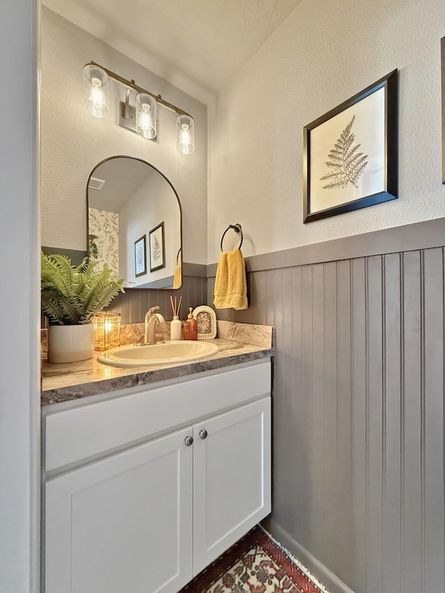 bathroom with vanity and wainscoting