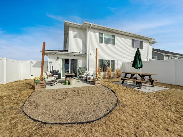 back of house featuring a fenced backyard, a yard, and a patio