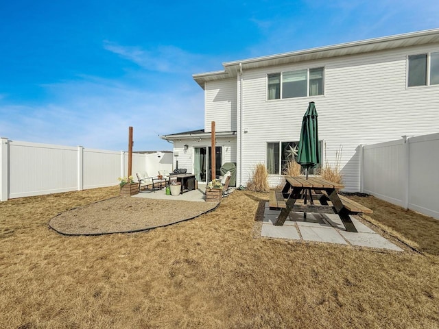 back of house featuring a patio, a yard, and a fenced backyard