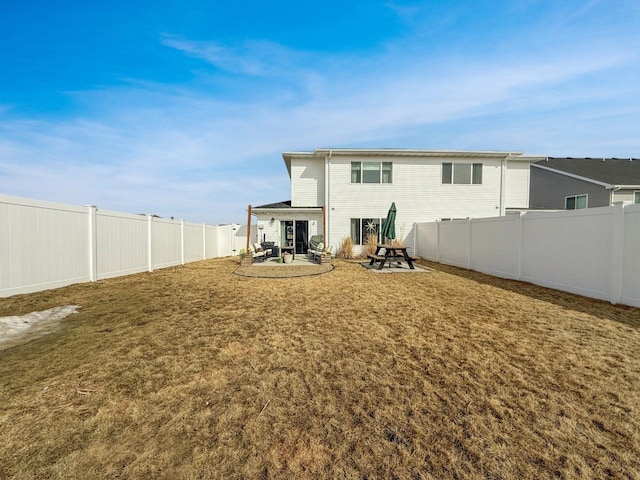 rear view of property with a patio, a lawn, and a fenced backyard