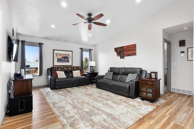 living room featuring visible vents, baseboards, lofted ceiling, wood finished floors, and a ceiling fan