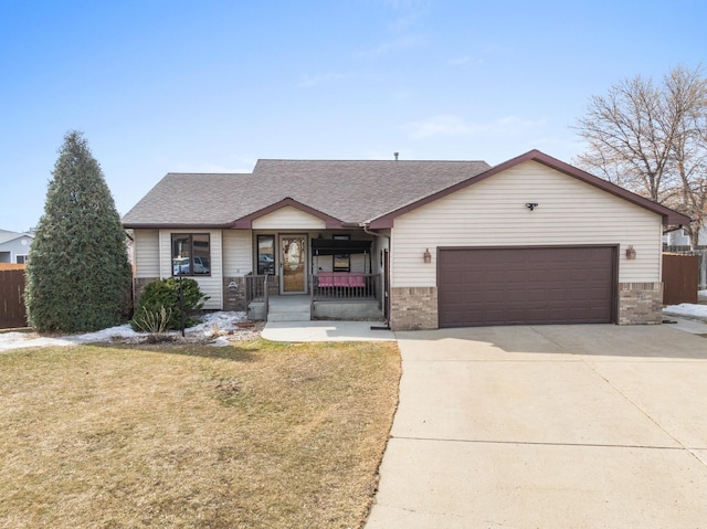 view of front of property featuring a front yard, roof with shingles, a porch, an attached garage, and concrete driveway