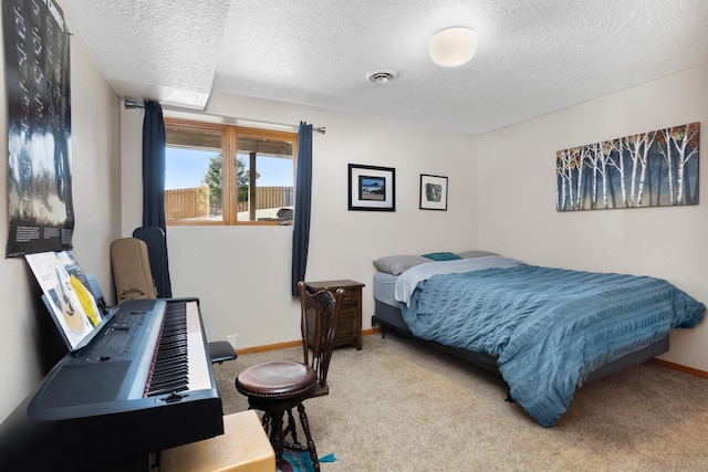 carpeted bedroom featuring visible vents, a textured ceiling, and baseboards