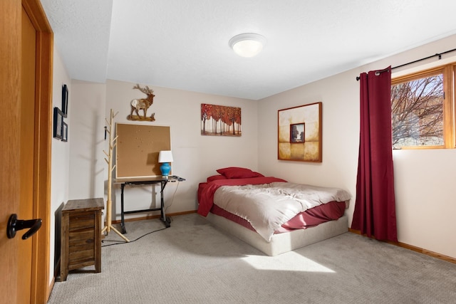 carpeted bedroom with a textured ceiling and baseboards